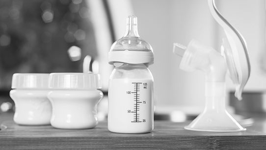A full bottle of breast milk and a breast pump