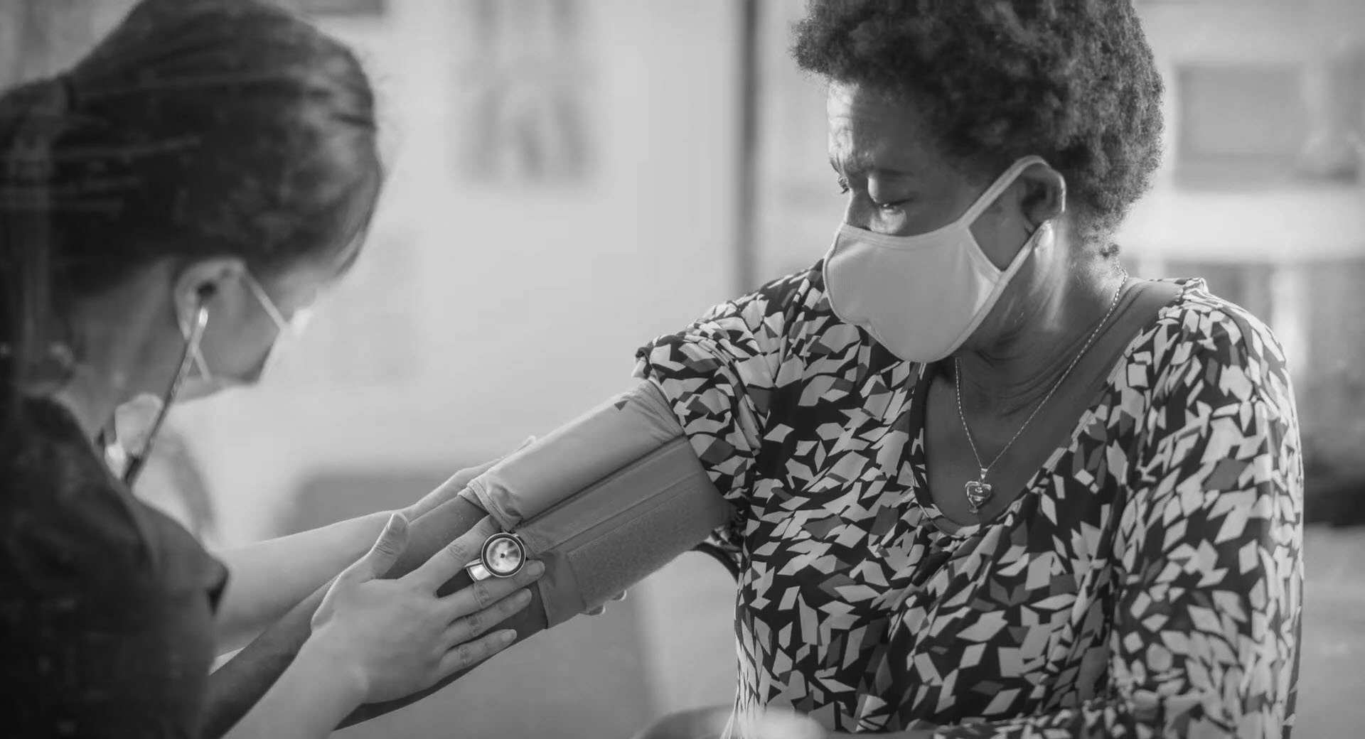A medical professional checks a woman's blood pressure.