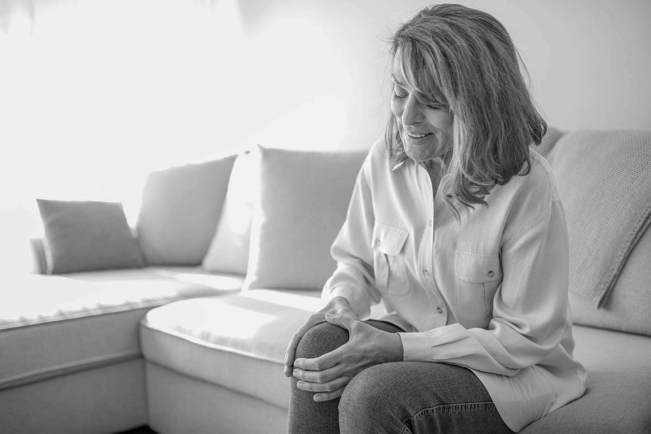 A woman holds her painful knee.