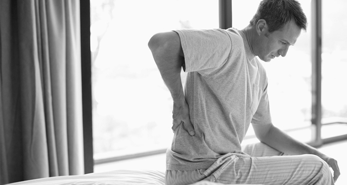 A man wakes up with back pain.