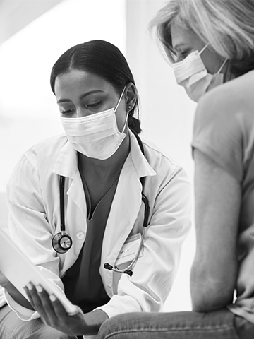 A doctor looks over paperwork with her patient. 