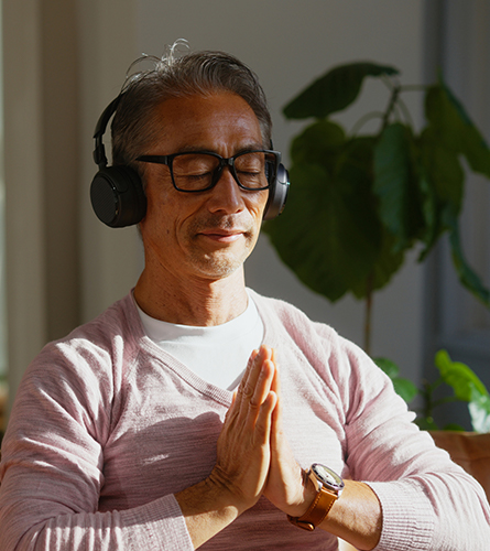 A man meditating while wearing headphones