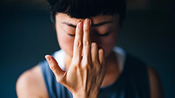 A woman holding her hand in front of her face a meditative state