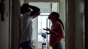 A couple having an emotional discussion in a hallway
