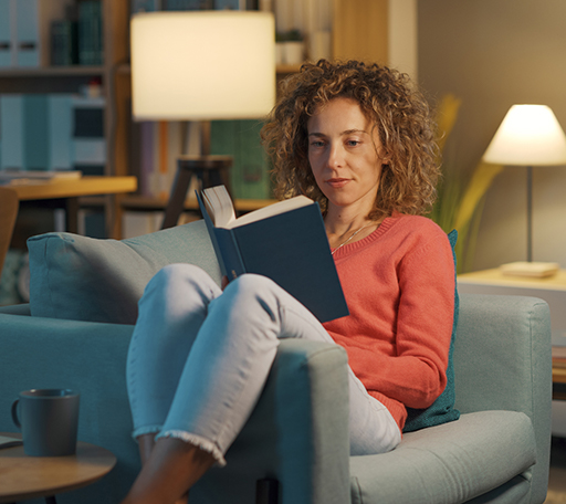 A woman relaxes in a comfortable chair while reading a book