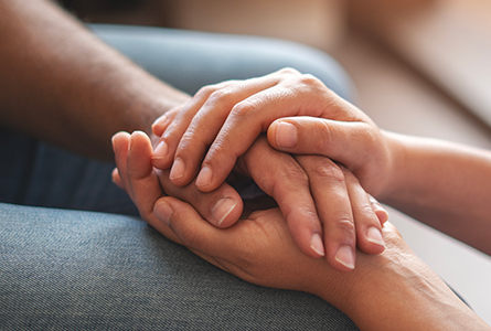 Two people hold hands