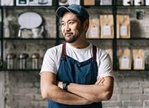 A man smiling with his arms crossed