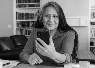 A woman smiles and looks at her phone