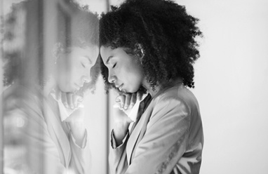 A woman rests her head on a window