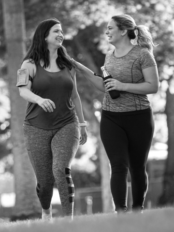 Two women support each other after a workout