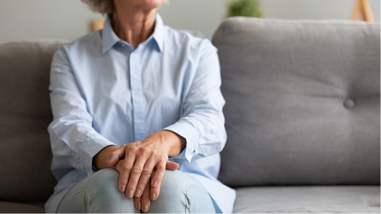 A woman calmly sits on a couch