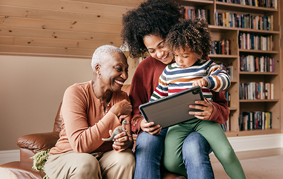A family shares a moment together while looking at a tablet.