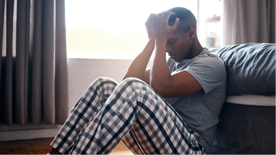 A man sits and struggles with depression