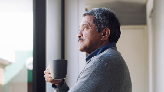 A man self reflects while drinking a cup of coffee