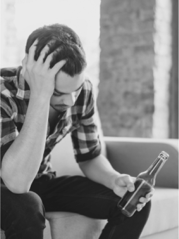 Man sits with beer in his hand