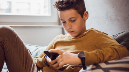 A boy reads on his smartphone