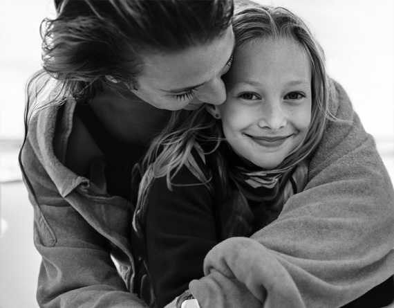 A woman wraps a towel around her daughter