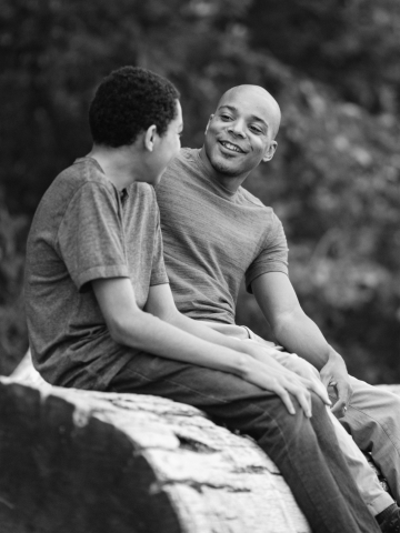 Father and son sit and talk together