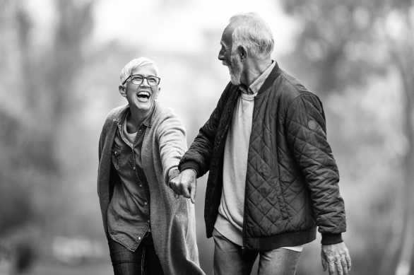 Two seniors laugh and walk together