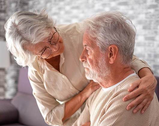An older woman looking after her husband with dementia