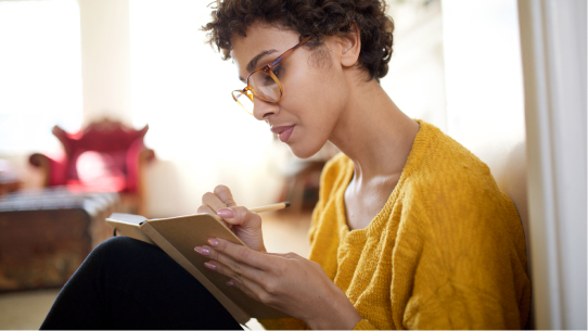 A woman writes in her journal 