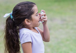 A photo of a young girl using an inhaler