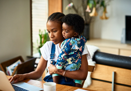 A photo of a mom and baby using a computer