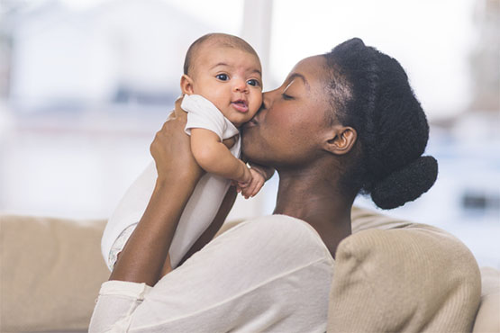 A young mother kisses her baby