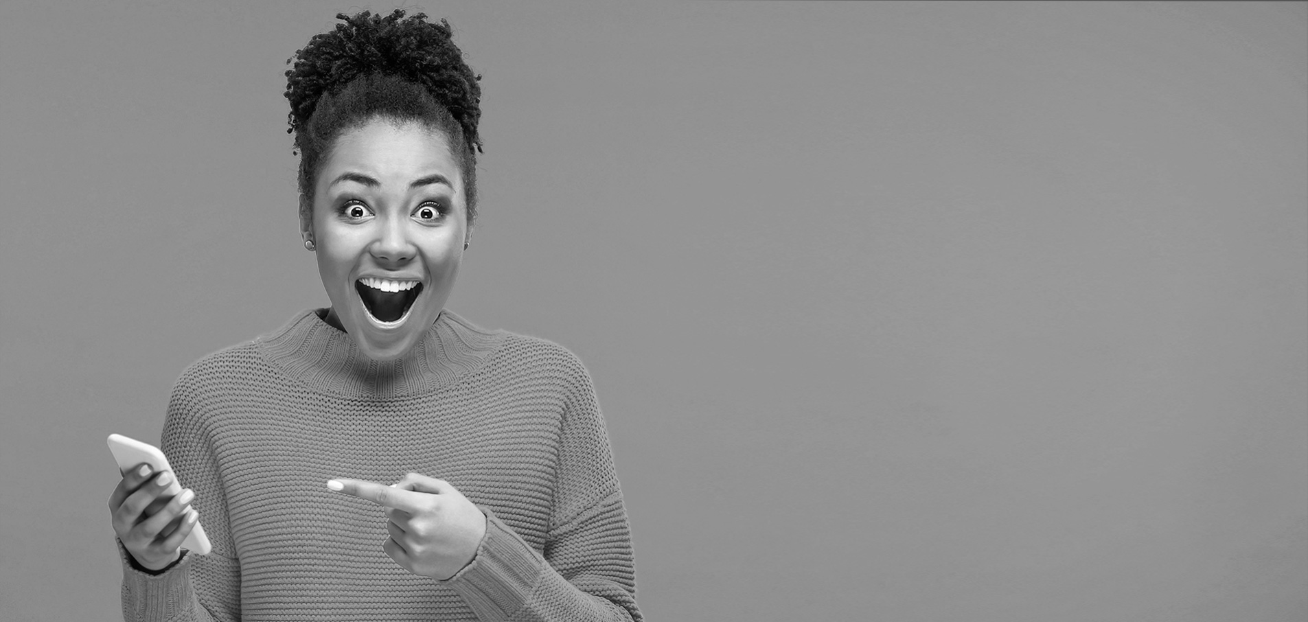 An enthusiastic woman points at her smartphone.