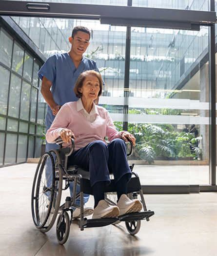 A medical professionsl pushes a woman in a whhelchair