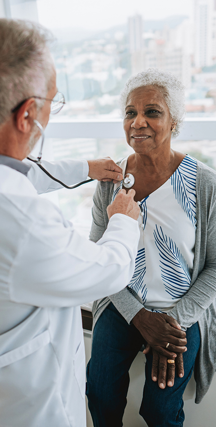 A medical professionsl performs an exam on a senior woman with a stehescope