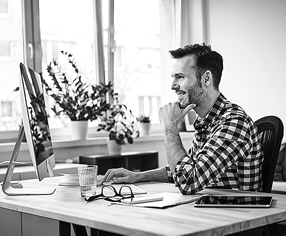  A man smiles while going to his appointment online. 