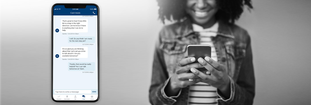 Woman holding a mobile device viewing the BCBSM app.