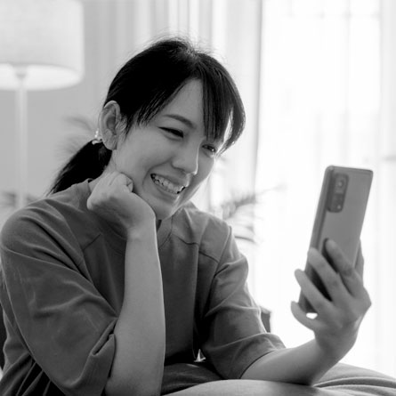 Woman looking into the screen of a mobile phone.