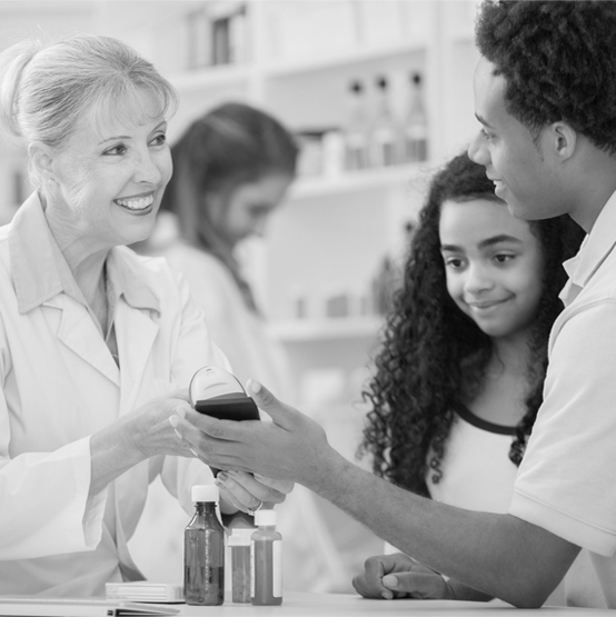 A pharmacist scans the mobile device of a customer  