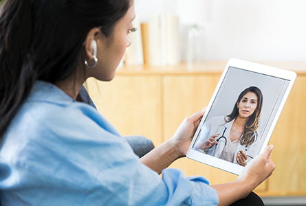 Woman communicating with mental health professional using tablet computer