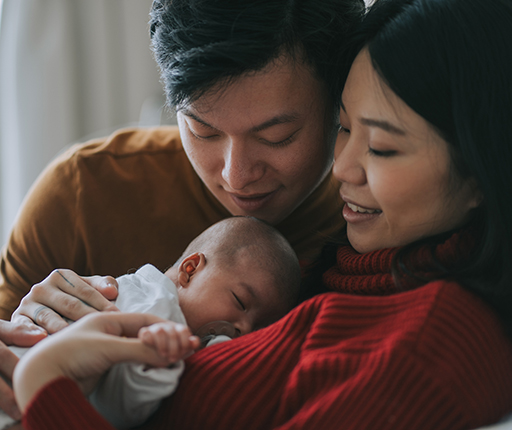 A couple hold a newborn baby.