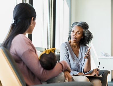 A mother and baby talk with a provider.
