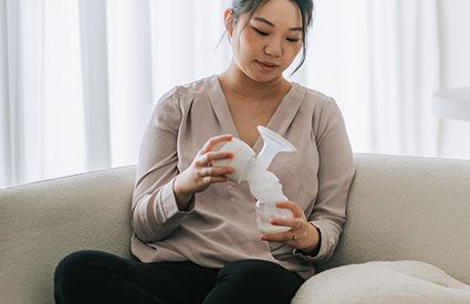 A woman holds a breast pump.