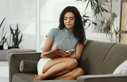 A young woman makes a list.