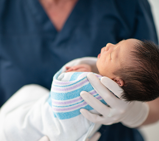 A provider holds a newborn baby.