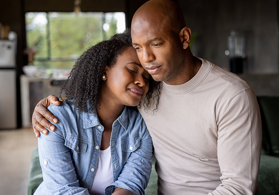 A sad man hugs a sad woman