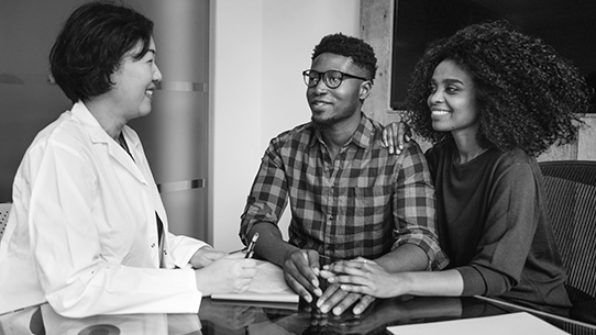 A doctor talks to a young couple