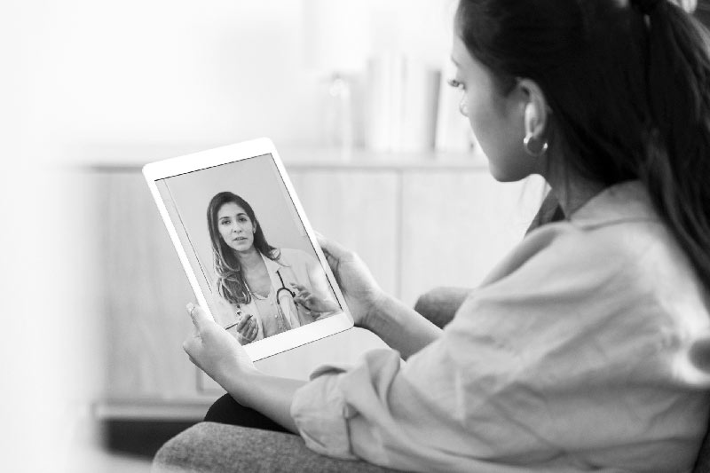 Woman communicating with mental health professional using tablet computer