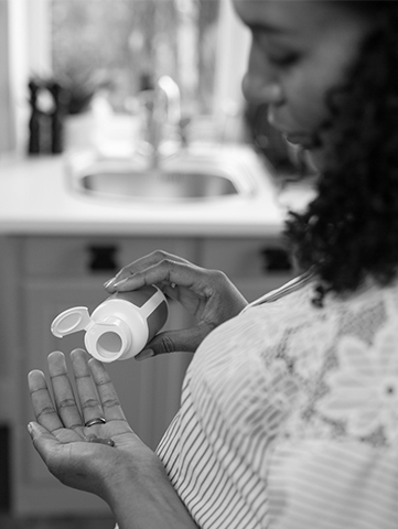 A woman holds her vitamins in her hands.