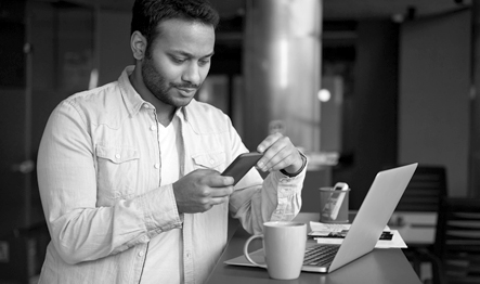 A man stands looking at his mobile phone