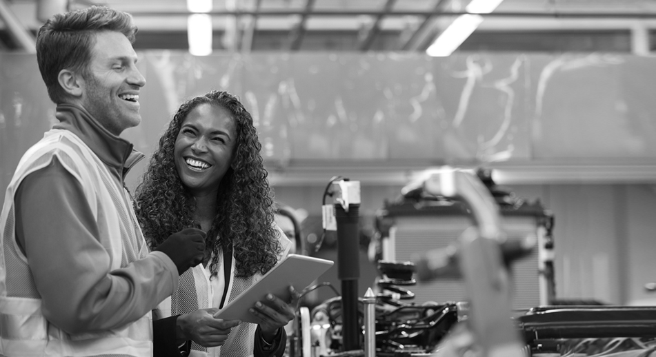 Two employees stand together laughing