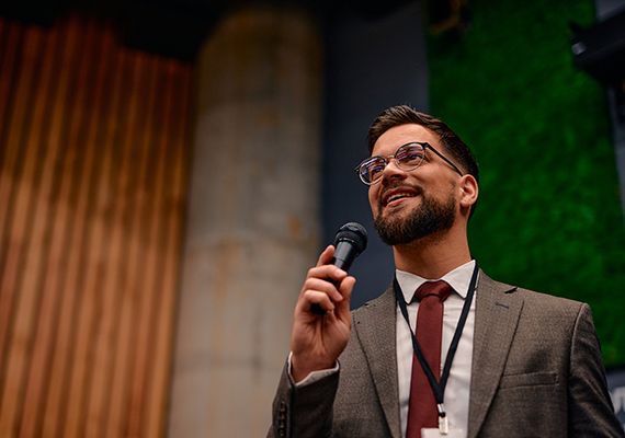 A man holds a microphone while giving a speech.