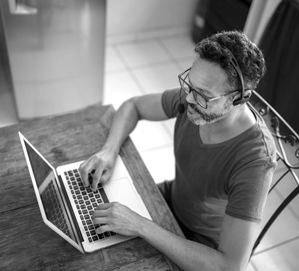 A man sits and types on his laptop. 