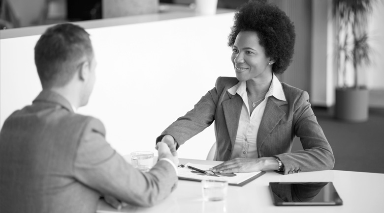 A woman shakes hands with a colleague. 